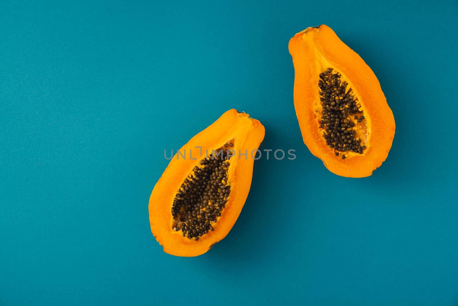 papaya fruit cutted on half on blue background. copy space