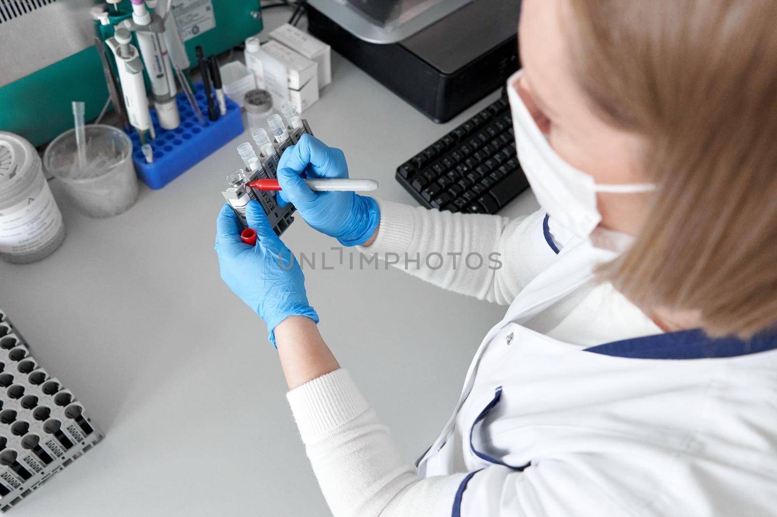 Female lab technician marking some samples with a red marker pen in an hospital