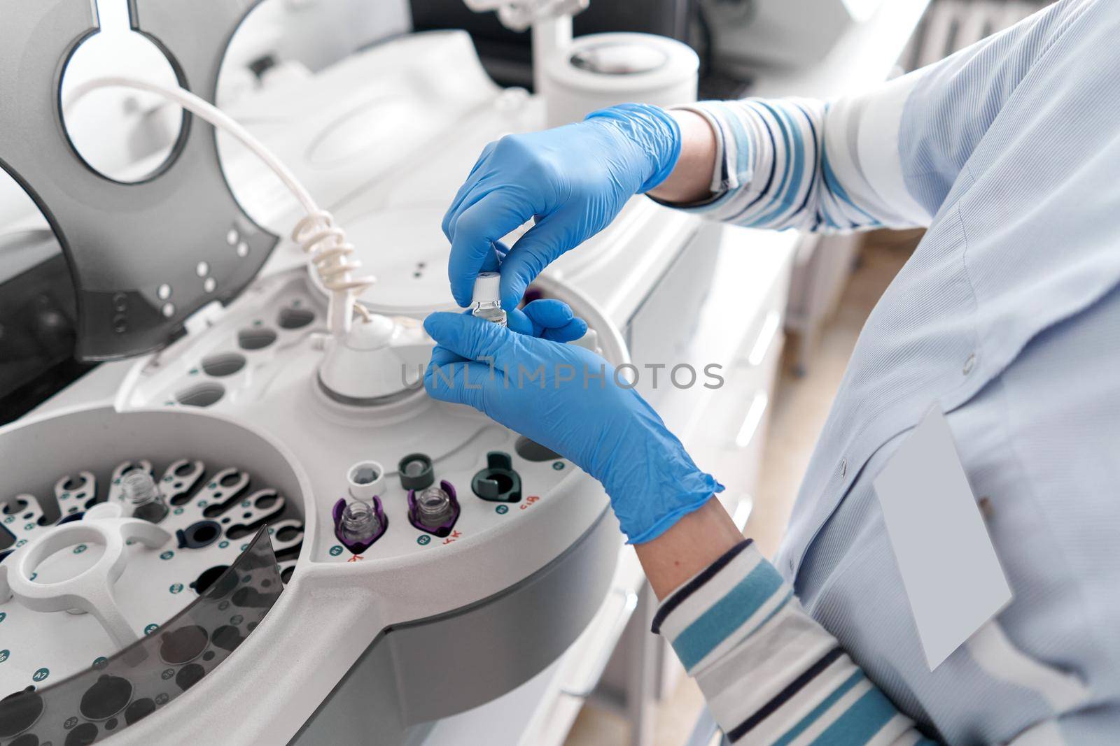 Hands of a laboratory technician working with a centrifuge machine in an hospital