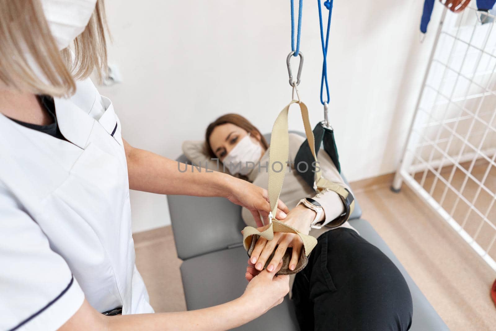 Physiotherapist rehabilitating a patient's hand that is stretching on a clinic