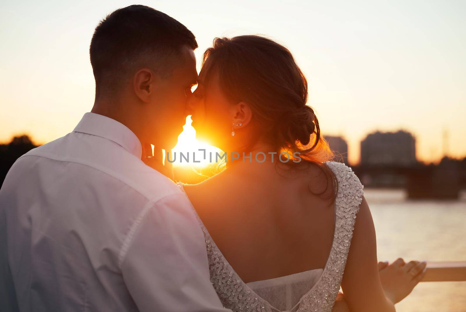 A kiss of the bride and groom at sunset. Wedding article. A happy couple. Love. Photos for printed products. by alenka2194