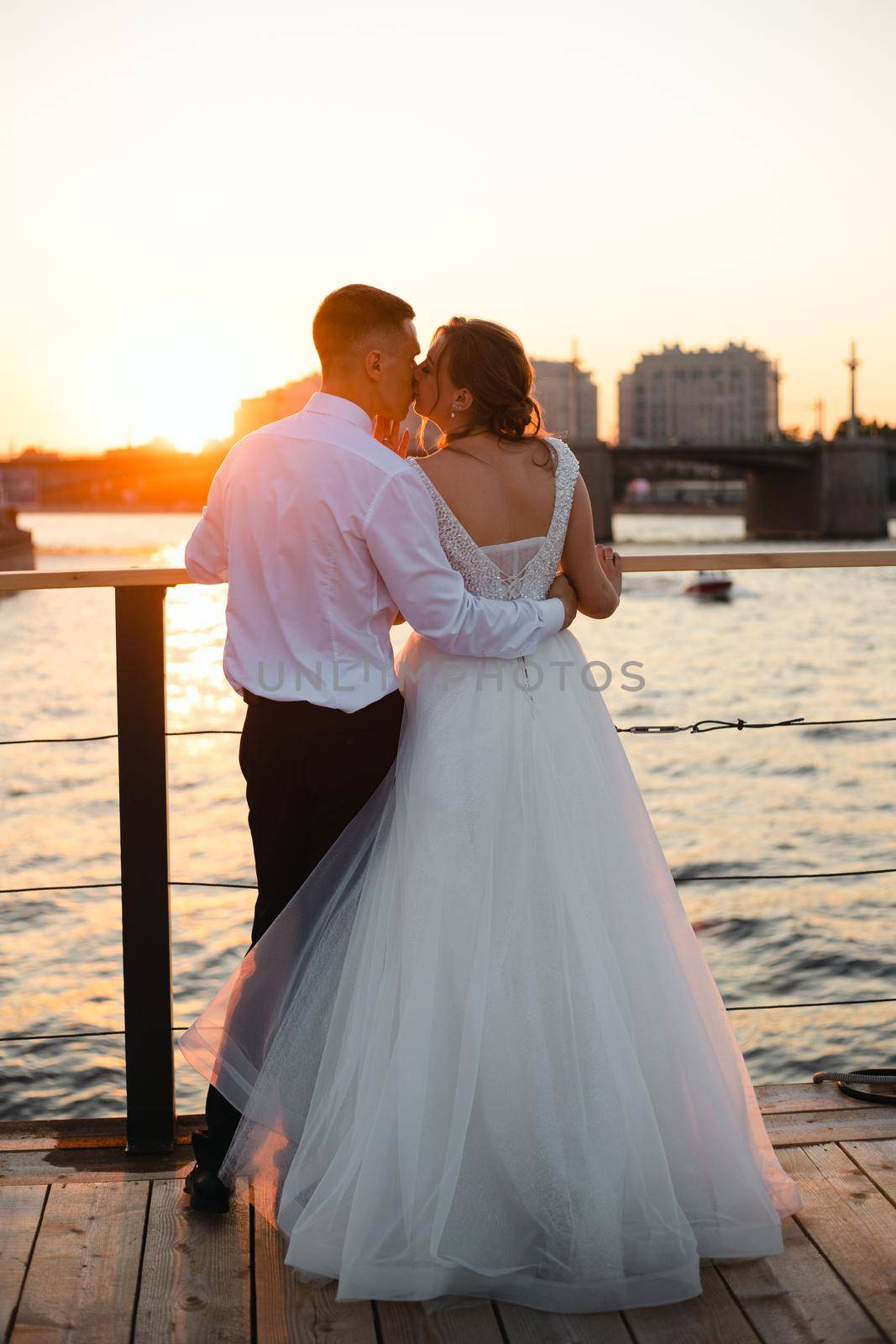 A kiss of the bride and groom at sunset. Wedding article. A happy couple. Love. Photos for printed products. by alenka2194