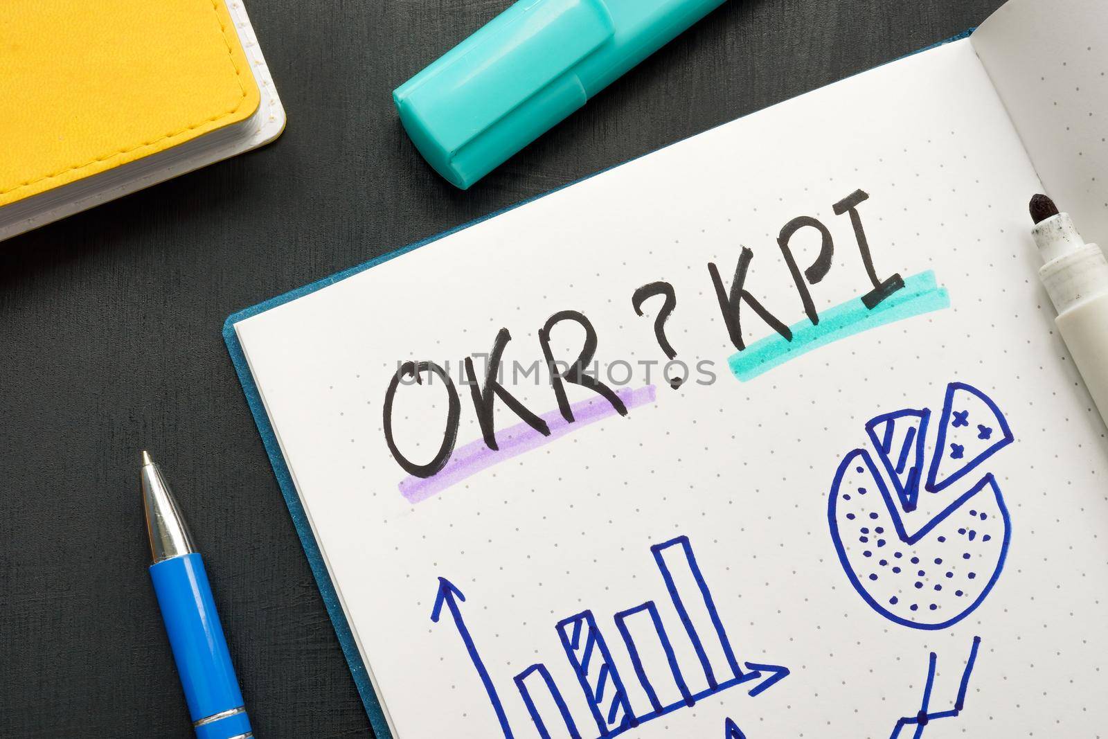 Marks in a notepad OKR or KPI and business charts.