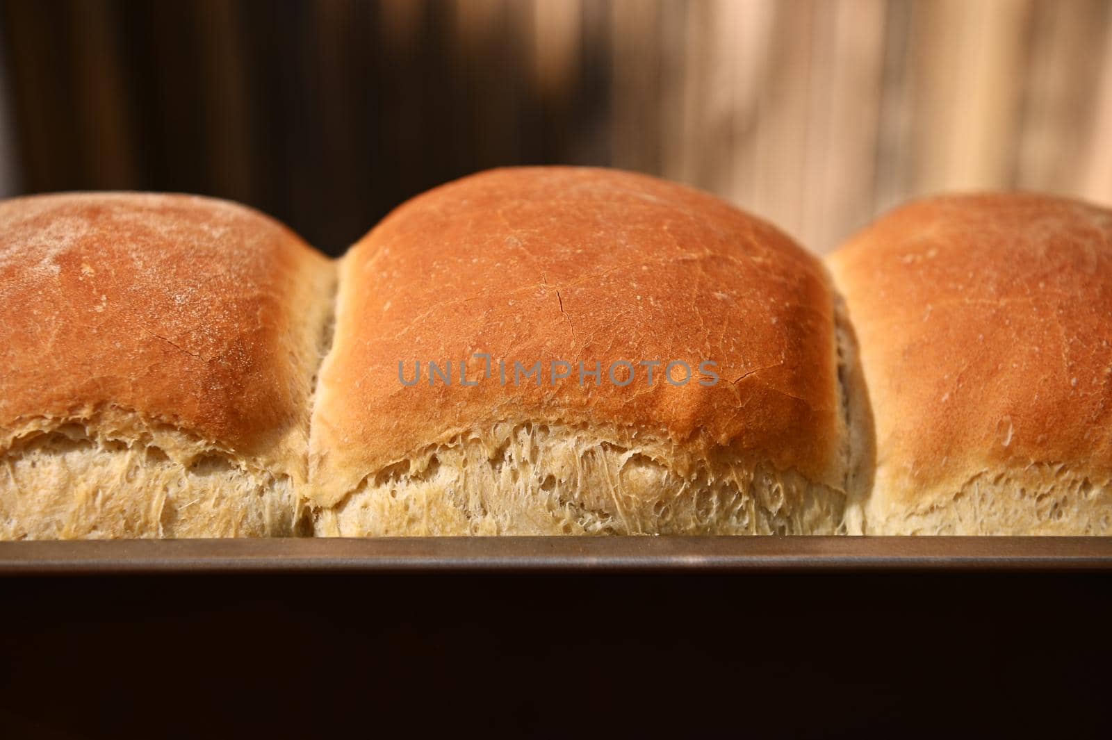 Cropped view of a baking dish with freshly baked hot whole grain bread, on a rustic wooden background with copy ad space for advertising text. Still life. Food composition.