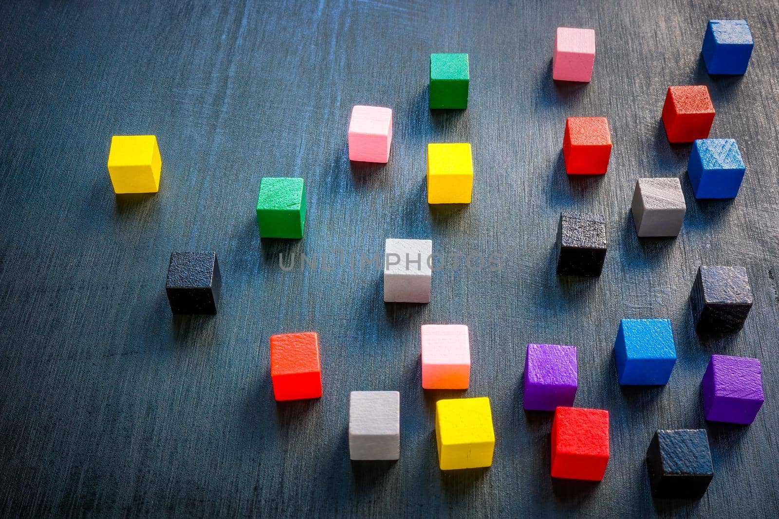 Colored cubes on dark surface. Leadership concept.