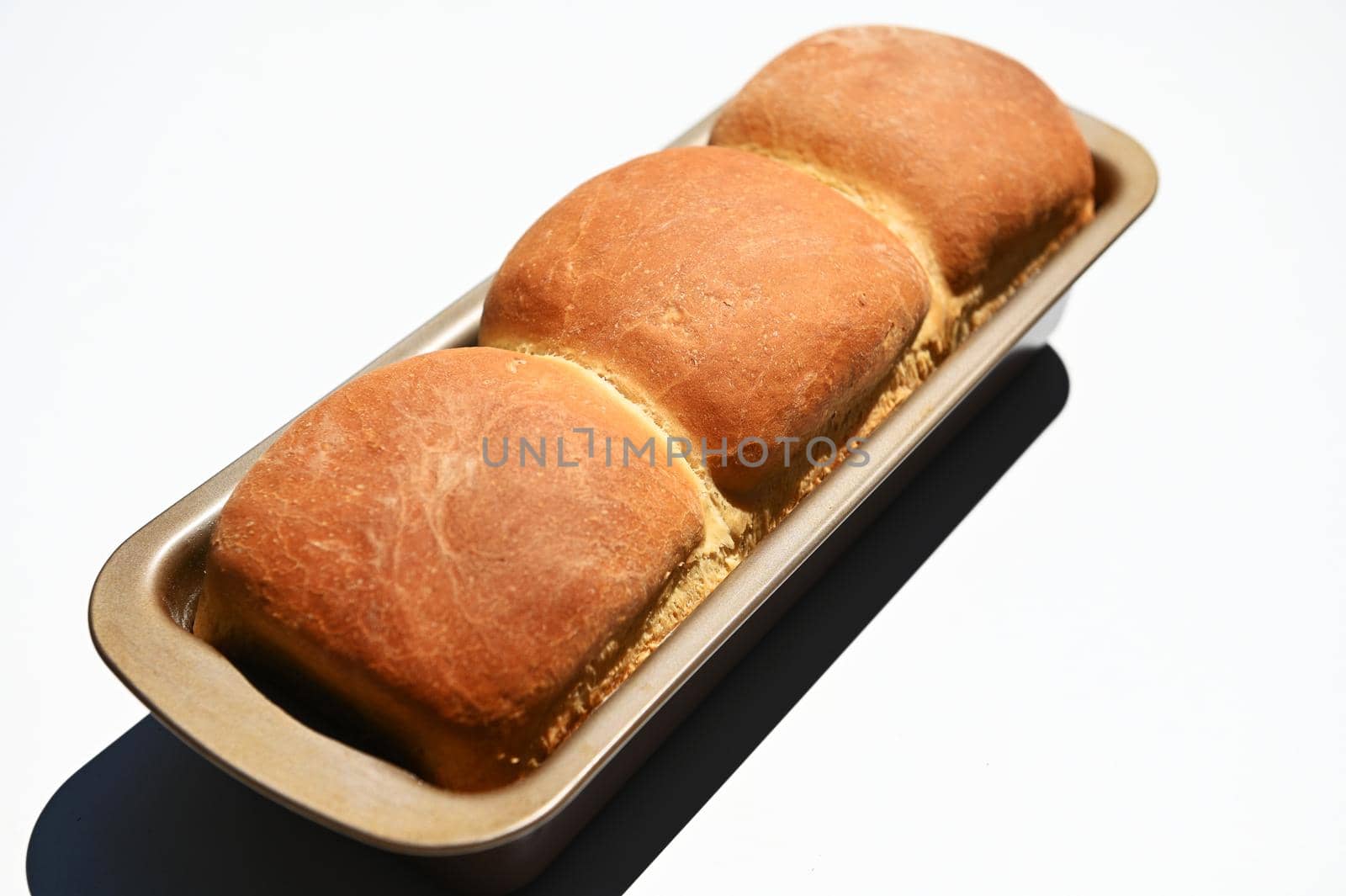 Close-up of a baking dish with freshly baked hot whole grain bread, isolated on white background with copy ad space for advertising text. Still life. Food composition. Flat lay
