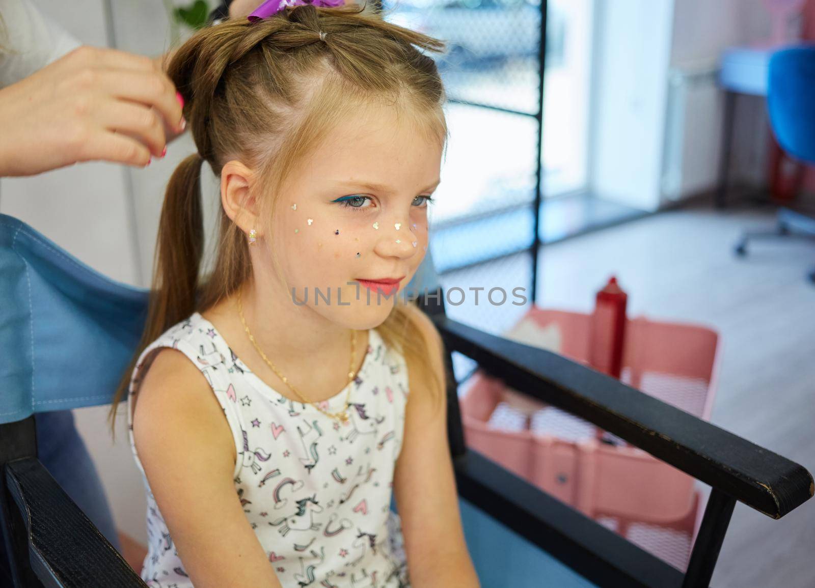 Hairdressing services. Reating hairstyle. Hair styling process. Children hairdressing salon.