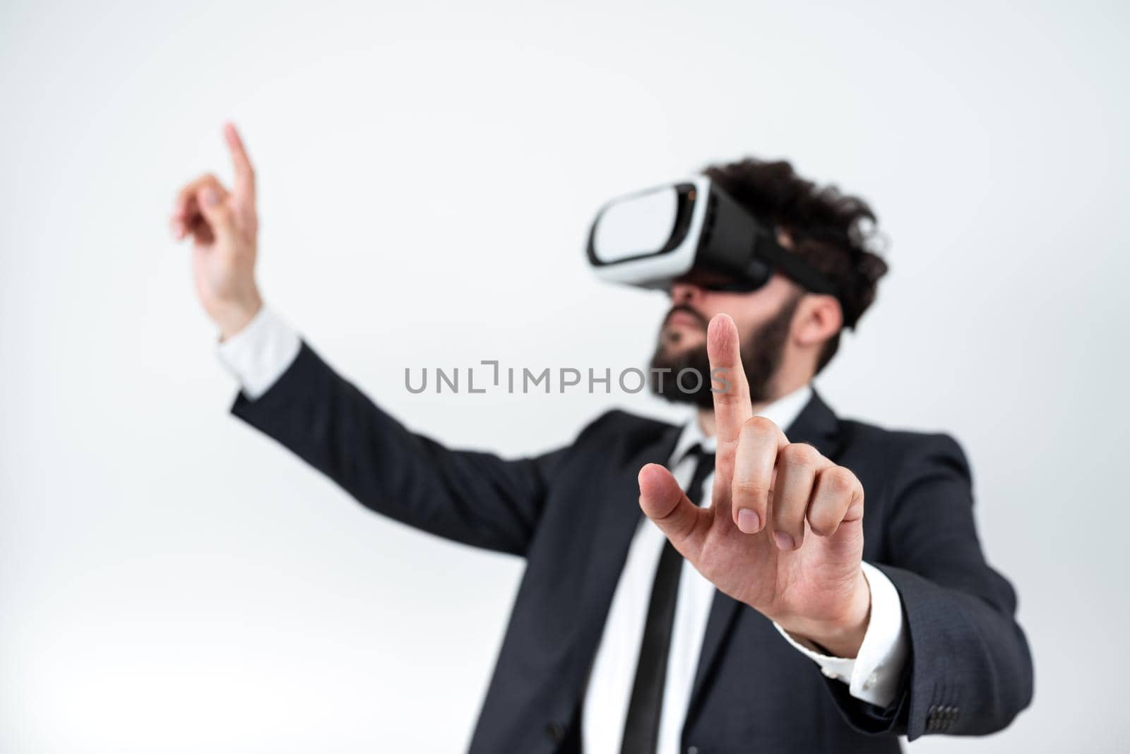 Man Wearing Vr Glasses And Pointing On Important Messages With Both Hands. Businessman Having Virtual Reality Eyeglasses And Showing Crutial Informations With Two Fingers. by nialowwa