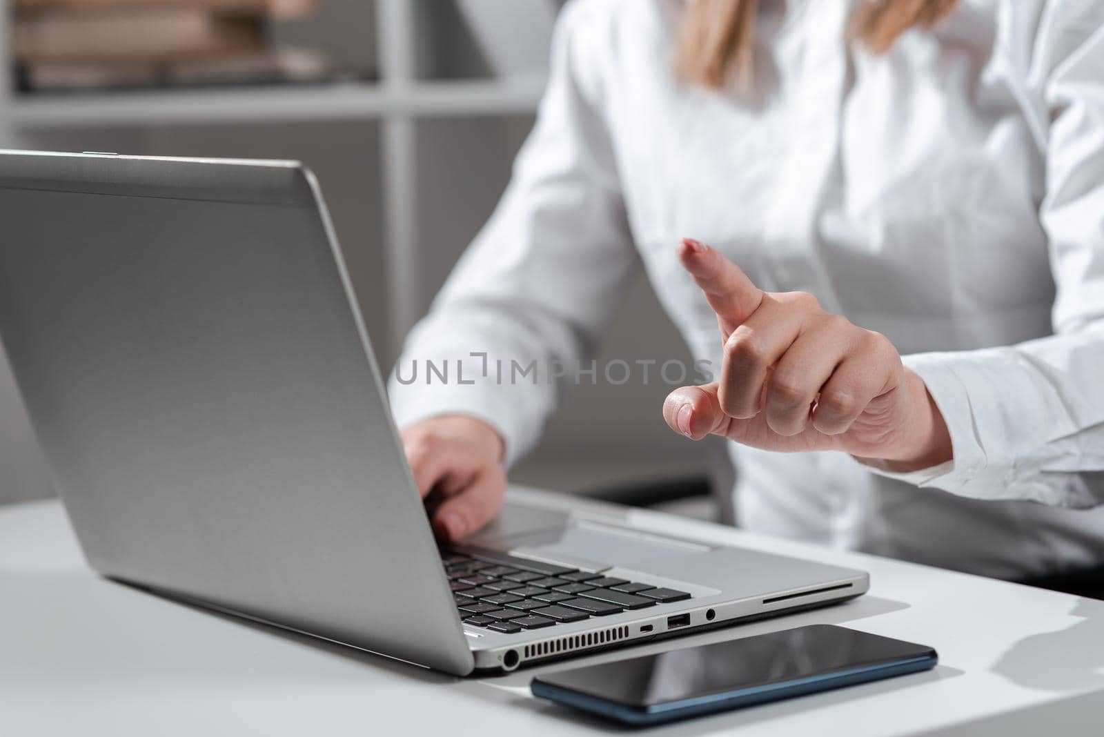 Woman Typing Updates On Lap Top And Pointing New Ideas With One Finger.