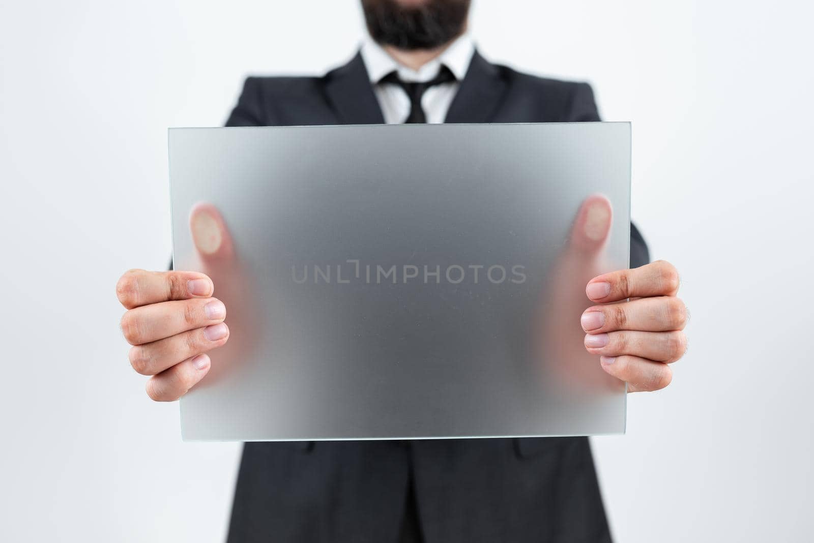 Professional Adult Holding Placard And Presenting Important Information. Businessman Wearing Suit Showing Rectangular Blank Board For Business Advertisement. by nialowwa