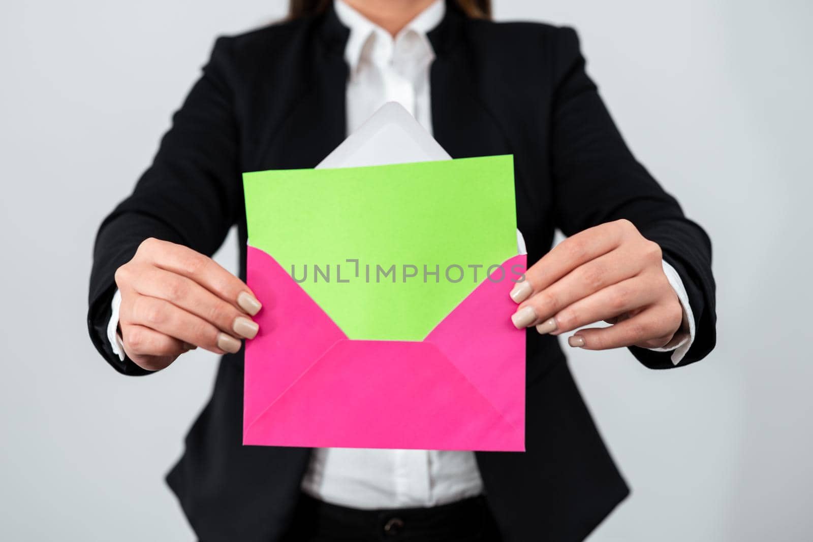 Businesswoman Wearing Suit Holding Envelope And Letter With Essential Information. Elegant Woman Having Postcard In Hands Presenting Crucial And Important Message. by nialowwa