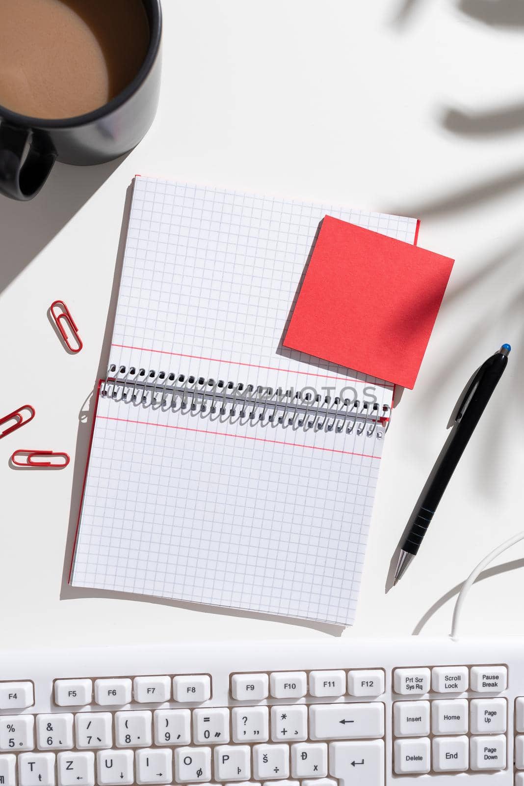 Notebook With Important Messages On Both Sides On Desk With Coffee, Pen, Paperclips, Keyboard And Memos. Crutial Information On Pad On Table With Cup And Pencil. by nialowwa