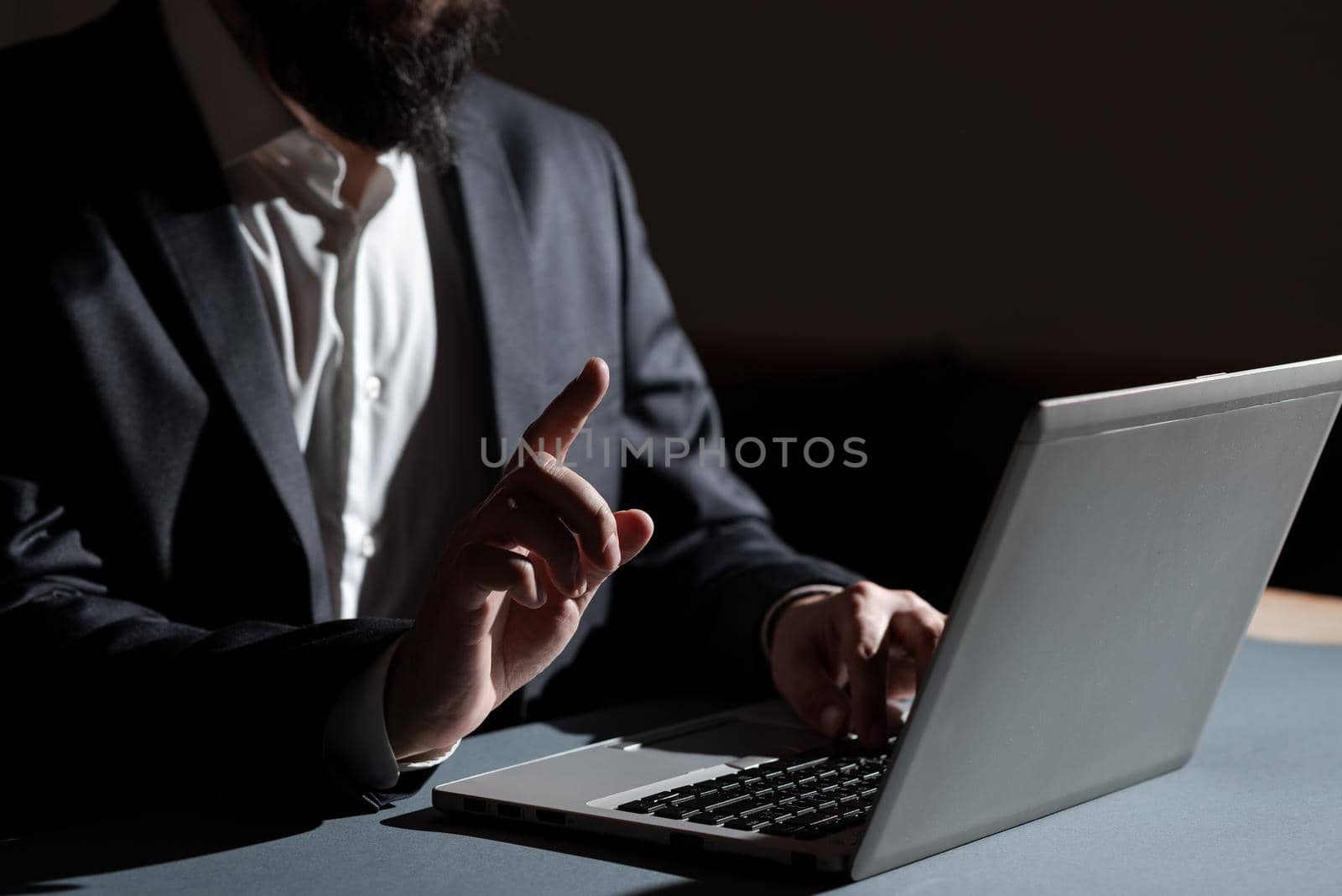 Businessman Typing Important Informations Into Lap Top And Pointing New Idea With One Finger. Man In Suit Writing Crutial Messages On Computer Keyboard. by nialowwa