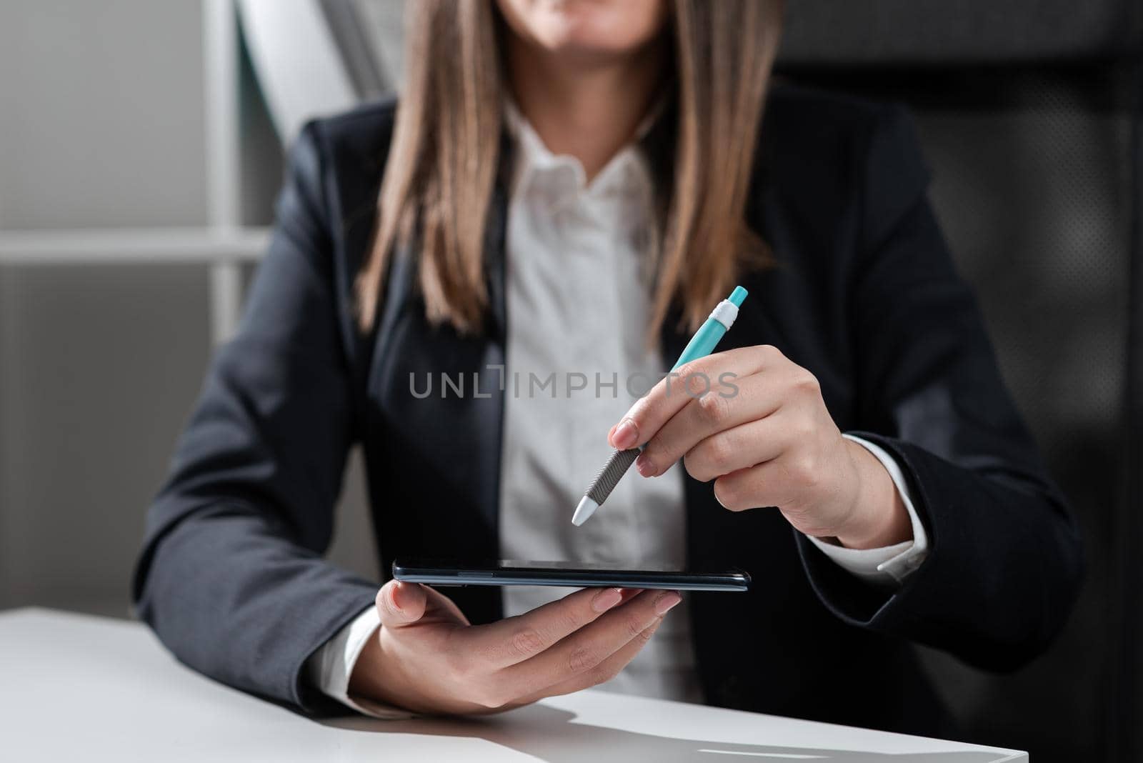 Businesswoman Holding Tablet In One Hand And Pointing On It With Pen.