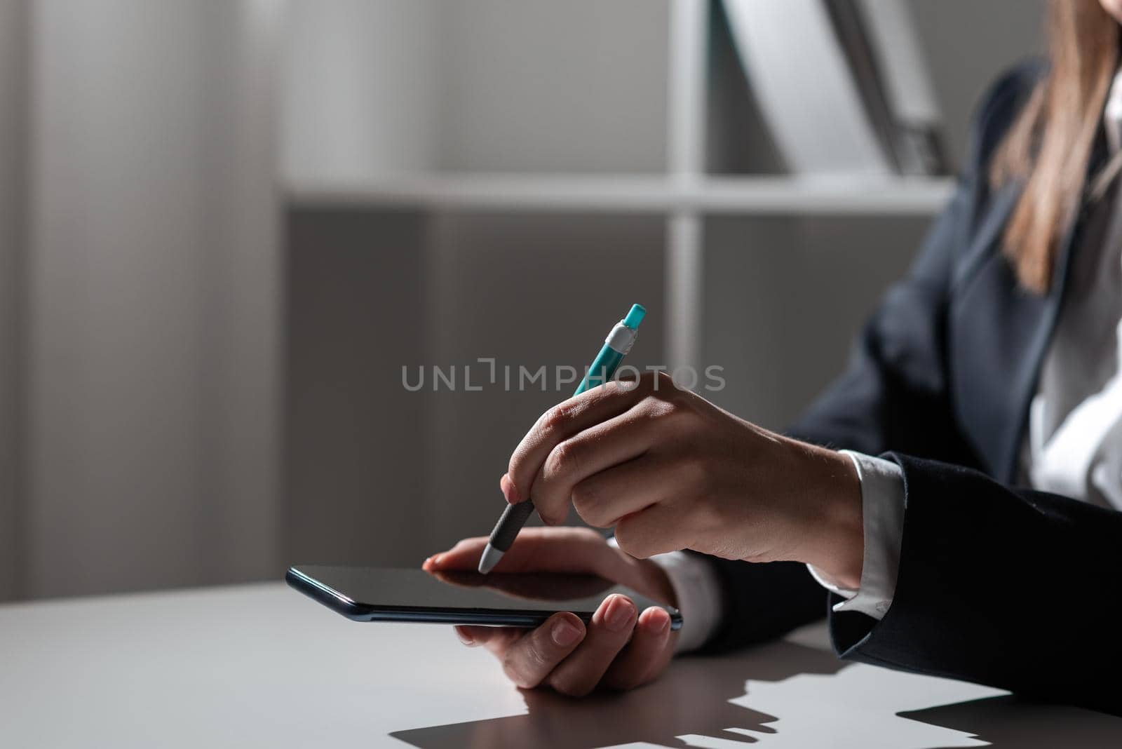 Businesswoman Holding Tablet In One Hand And Pointing On It With Pen.