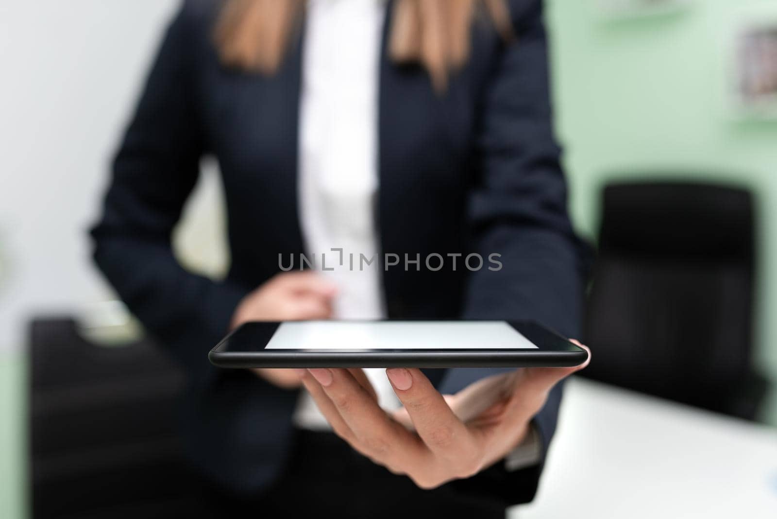 Businesswoman Holding Tablet And Presenting Important Message. Woman Having Phone In Hands And Showing Crutial Information. Executive Displaying Recent Updates. by nialowwa