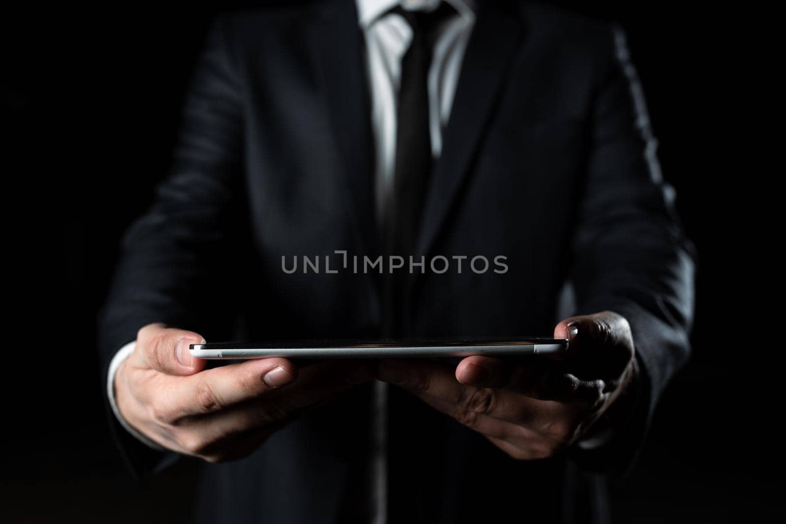Businessman Holding Tablet With Both Hands And Presenting Important Data. Man In Suit Showing Crutial Information. Executive Displaying Crutial Announcement. by nialowwa
