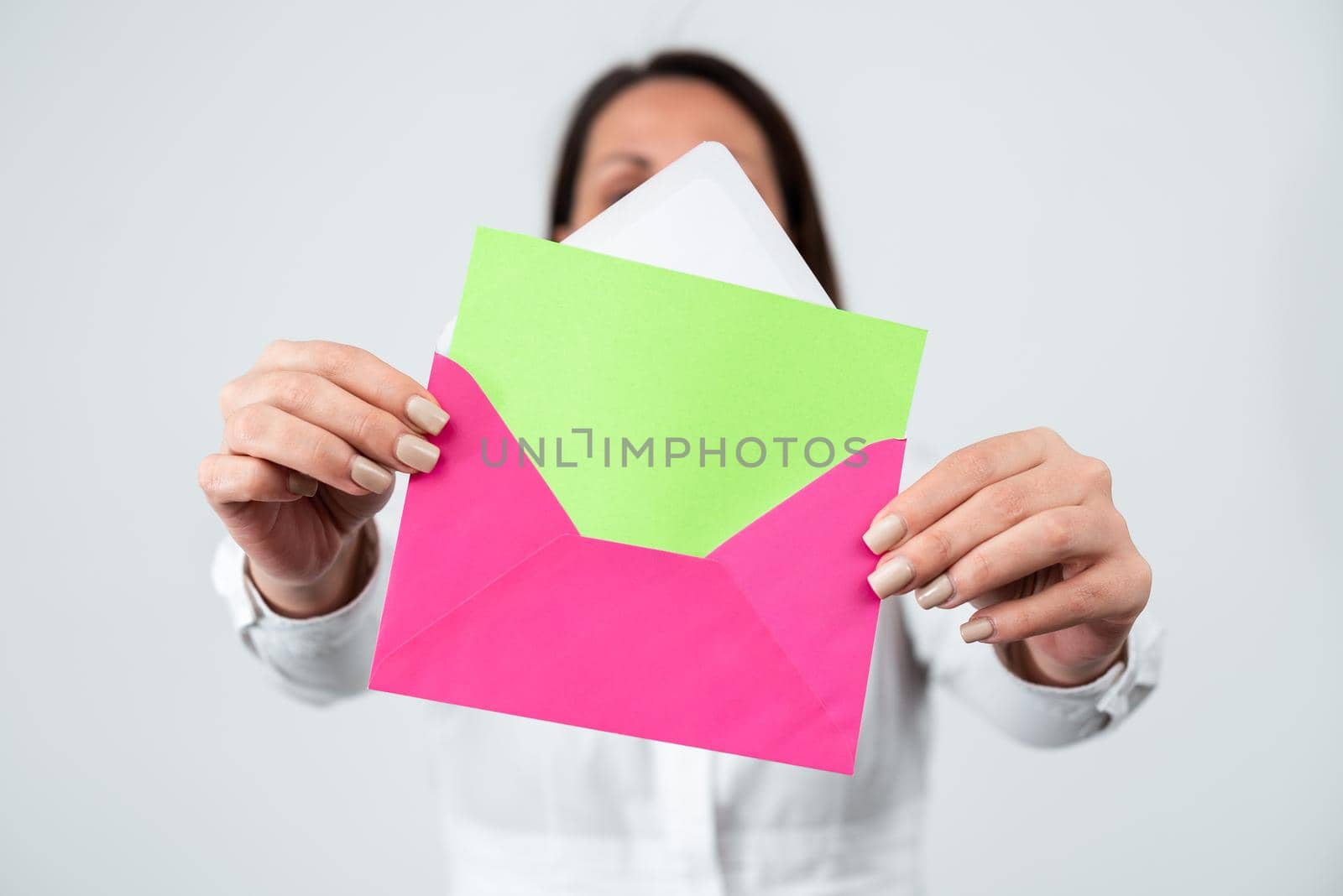 Female Professional Holding Envelope And Letter In Hands With Important Message. Businesswoman Showing Postcard And Presenting Crucial Information For Business Progress. by nialowwa