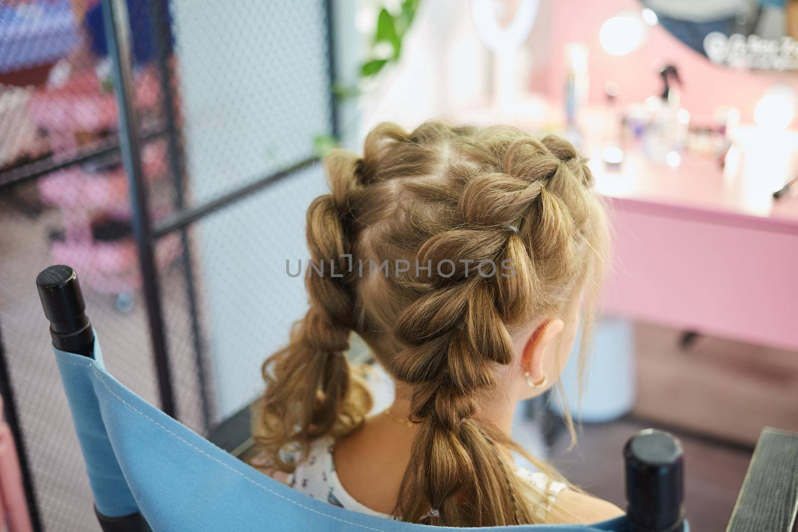 Hairdressing services. Reating hairstyle. Hair styling process. Children hairdressing salon.