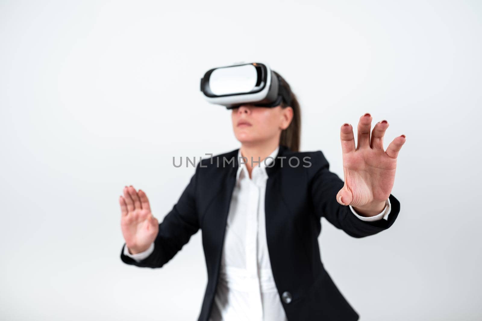 Woman Wearing Vr Glasses And Presenting Important Messages Between Hands. Businesswoman Having Virtual Reality Eyeglasses And Showing Crutial Informations. by nialowwa