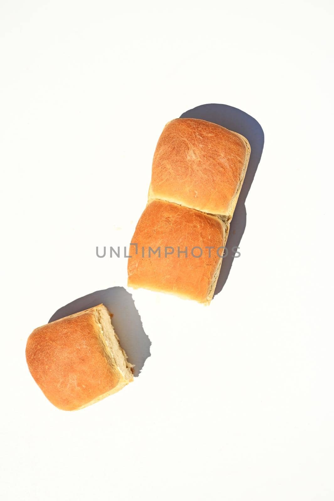Flat lay composition of a fresh baked whole grain buns on a white background with copy ad space for advertising text.
