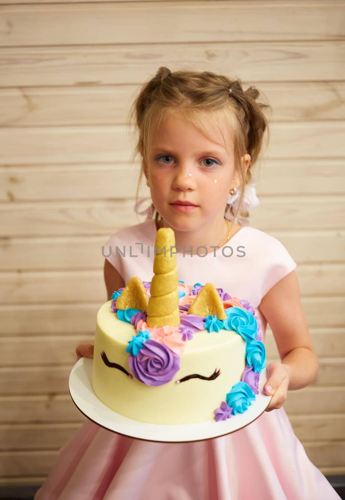 girl holding a cake in the form of a Unicorn by sarymsakov