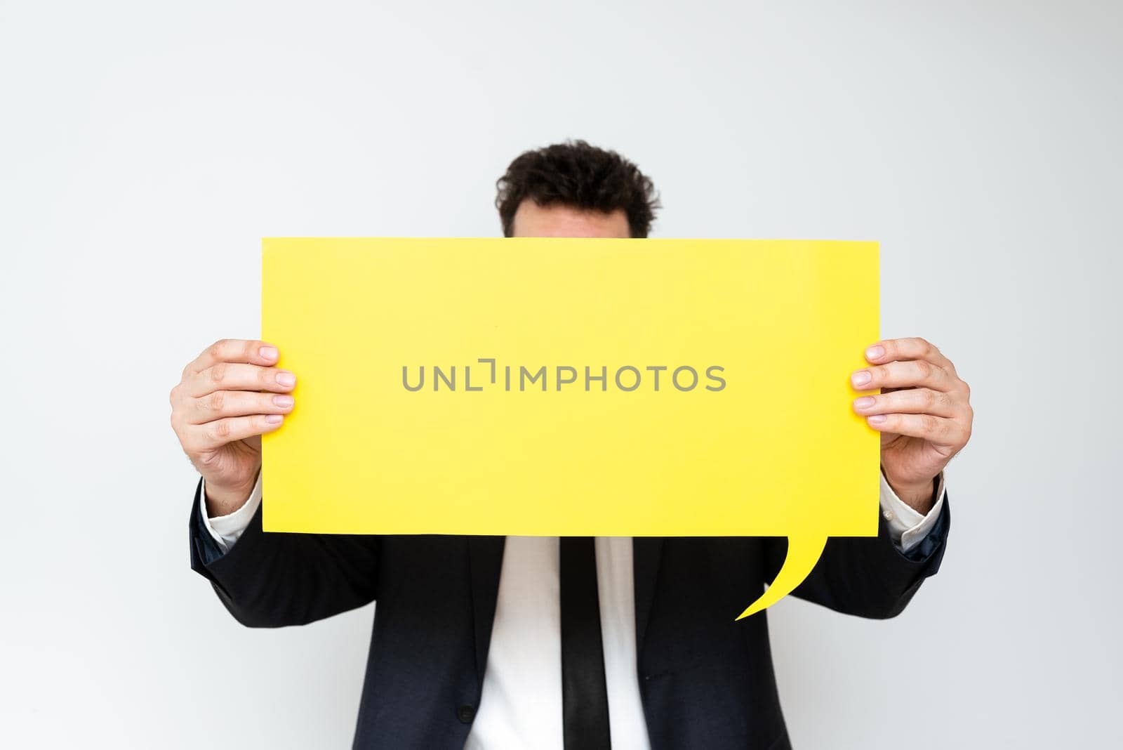 Businessman Holding Speech Bubble With Important Messages. Man In Suit Presenting Crutial Informations On Dialogue Balloon. Gentleman Showing Recent Updates On Paper. by nialowwa