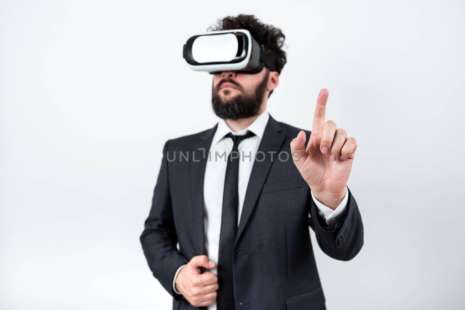 Man Wearing Vr Glasses And Pointing On Important Messages With One Finger. Businessman Having Virtual Reality Eyeglasses And Showing Crutial Informations. by nialowwa