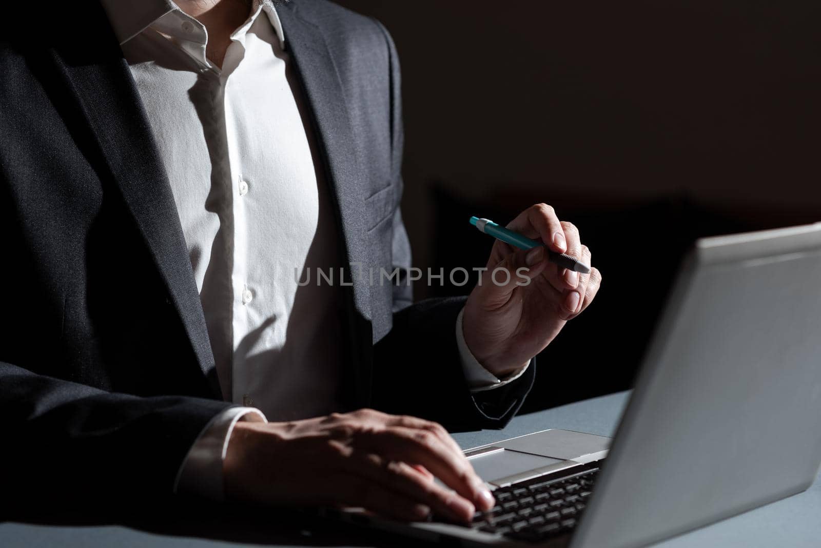 Businessman Typing Important Concept Into Lap Top And Pointing New Idea With Pen. Man In Suit Writing Crutial Messages On Computer Keyboard. Executive Presenting Late Data. by nialowwa