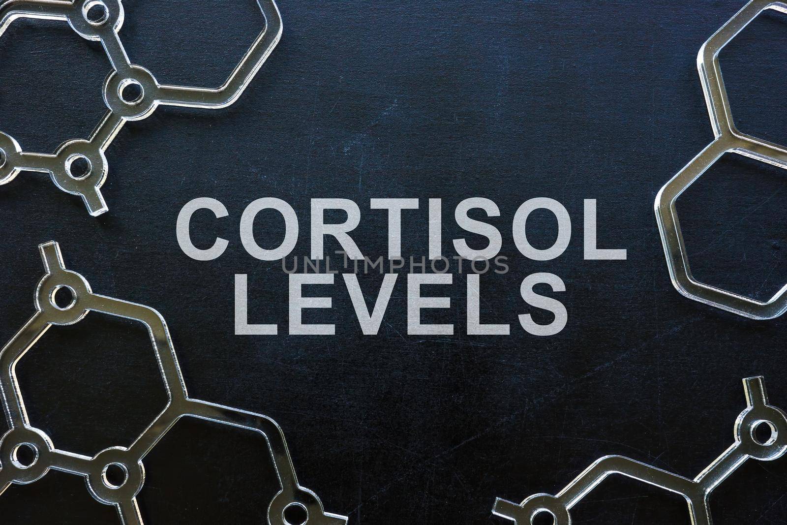 Cortisol levels phrase on blackboard and molecule models.