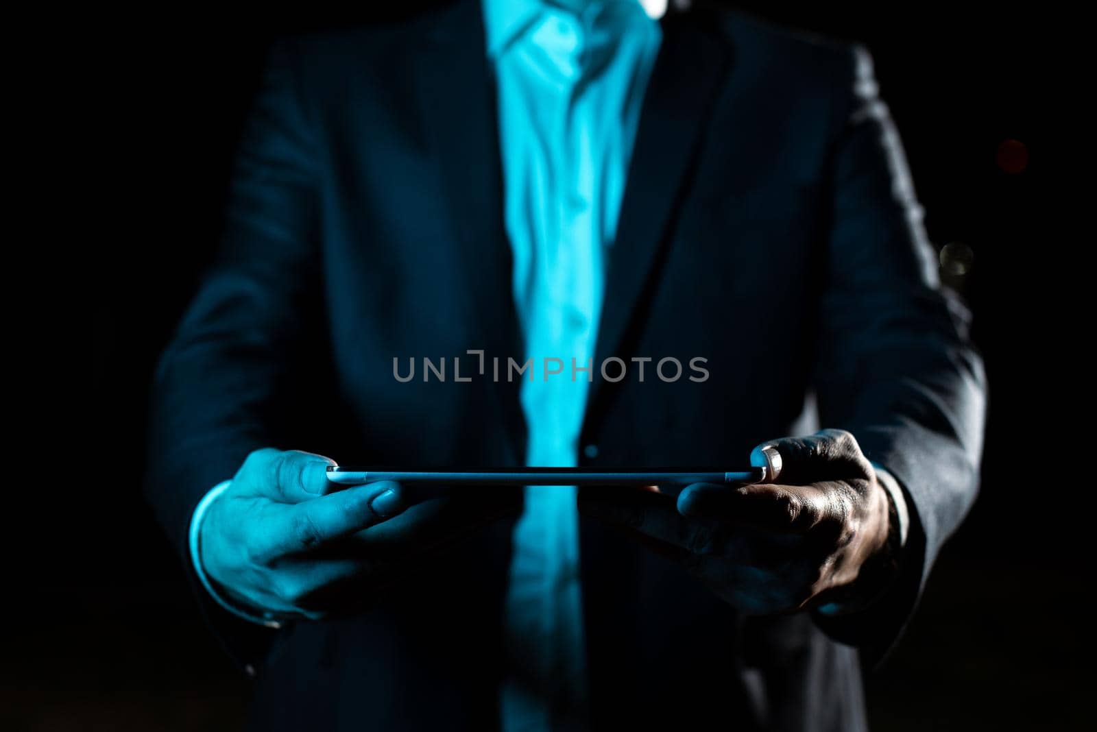 Businessman Holding Tablet With Both Hands And Presenting Important Data. Man In Suit Showing Crutial Information. Executive Displaying Crutial Announcement. by nialowwa