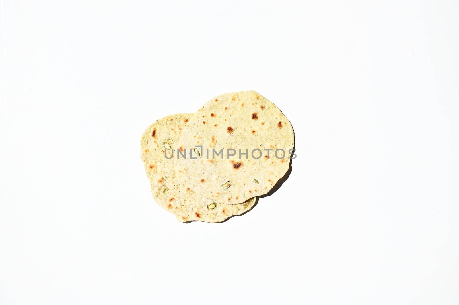 Flat lay of freshly baked homemade chapati, pita bread, flatbread, isolated over white background with copy space for advertising text. Top view, still life, food background