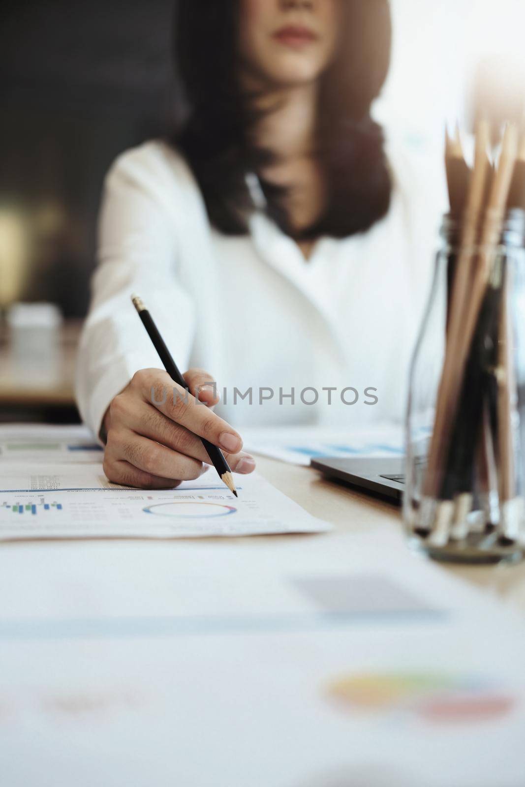 focus woman holding a pencil Auditors use budget document calculators to find annual budget disbursement errors. by Manastrong