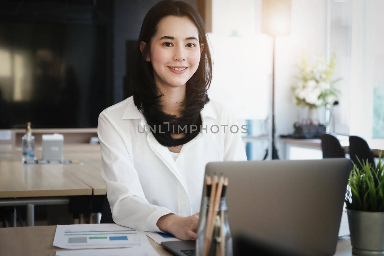 Female employees are working at home through computers to maintain social distancing to reduce the spread of coronavirus. by Manastrong