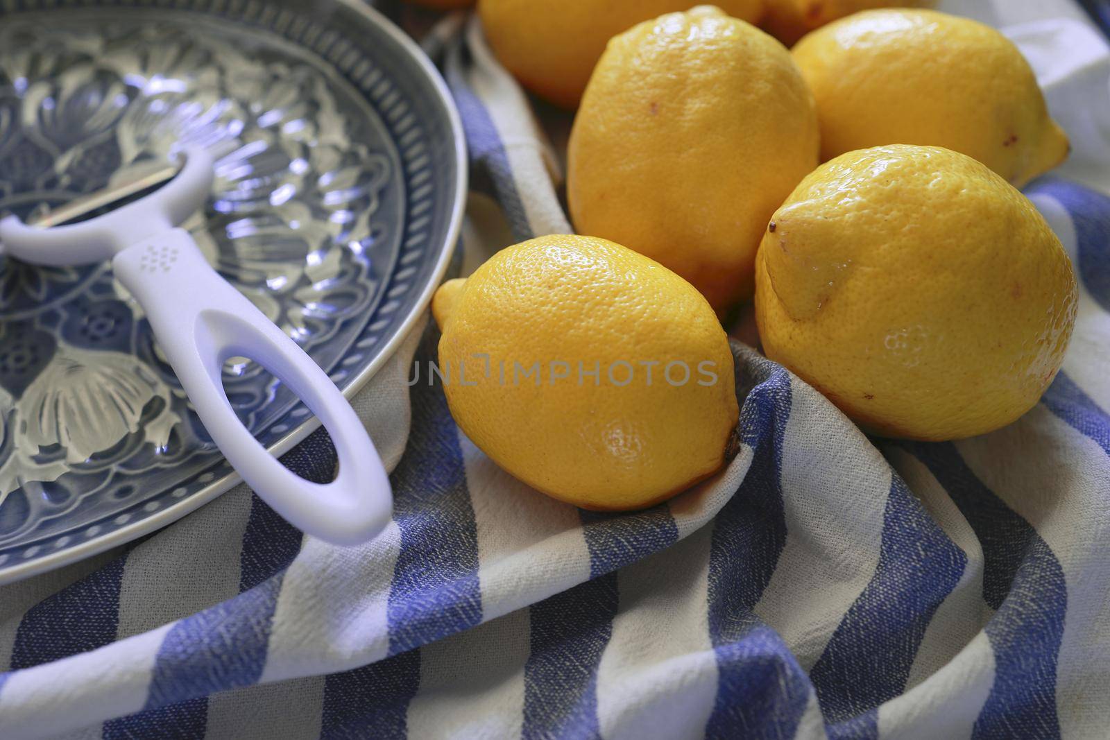 Lemon fruits and peeler for zest to make limoncello. Peeler, lemons and zest. Copy space, selected focus by Proxima13