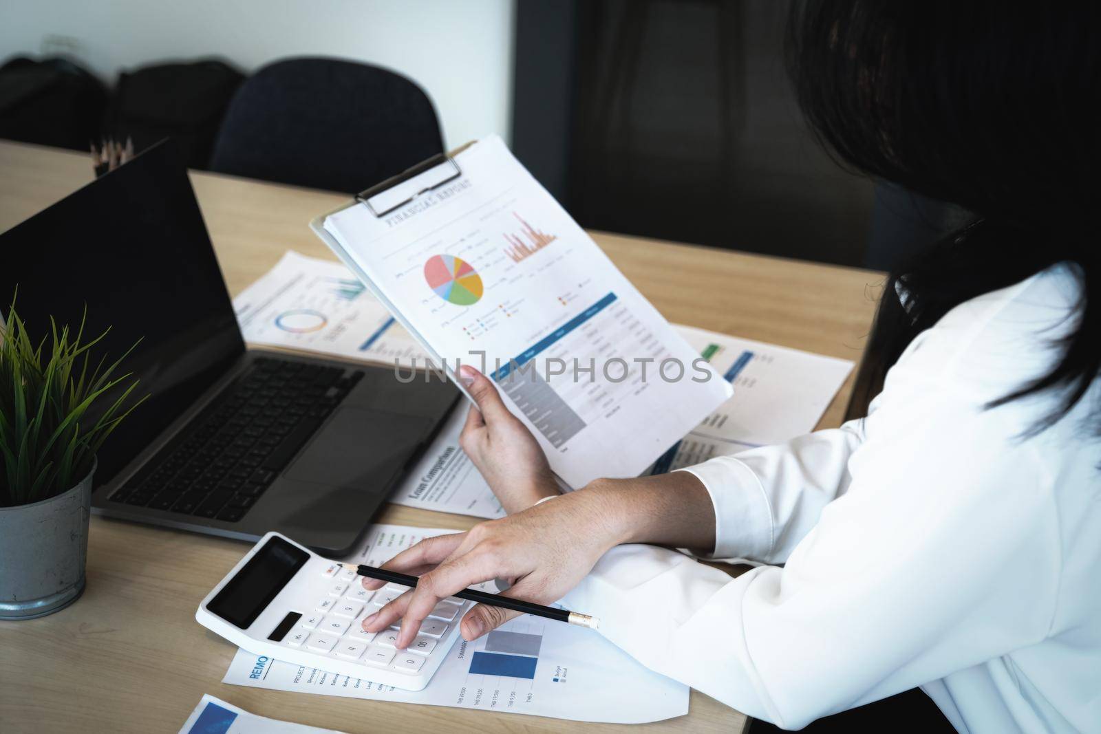 Business owners use calculators to calculate with financial documents to analyze third-party profits to invest in company stocks. by Manastrong