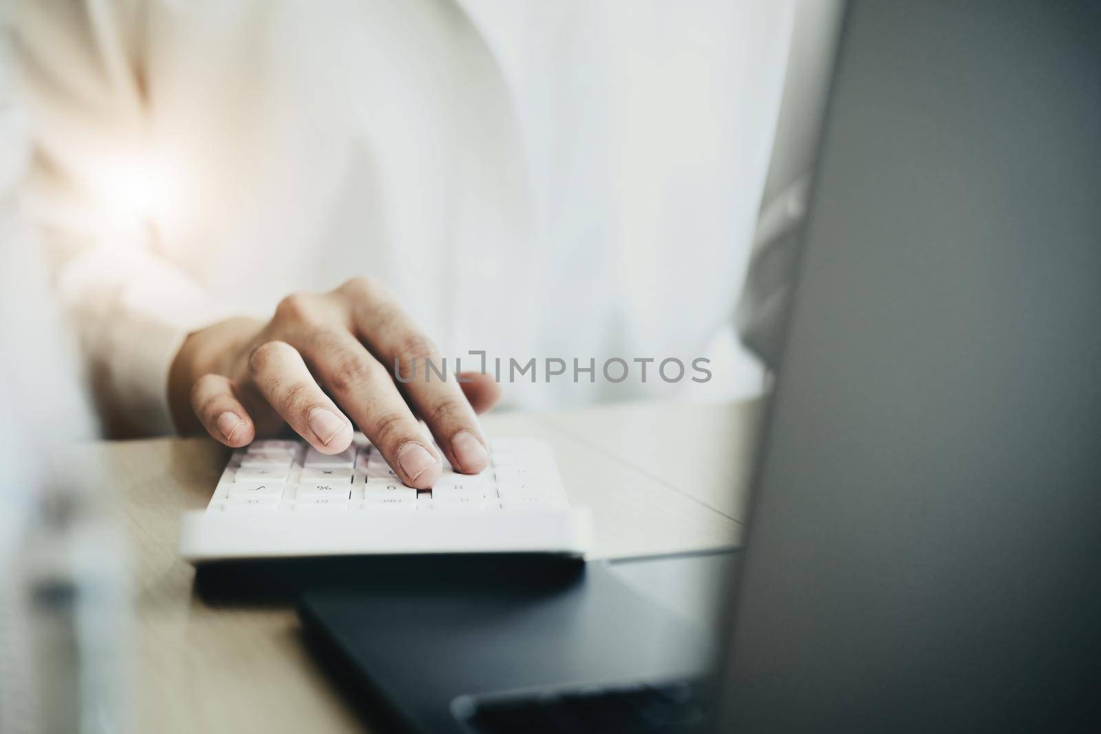 Business woman using calculator to review balance sheet annual using document and laptop computer to calculating budget. audit and Check integrity before investment concept. by Manastrong