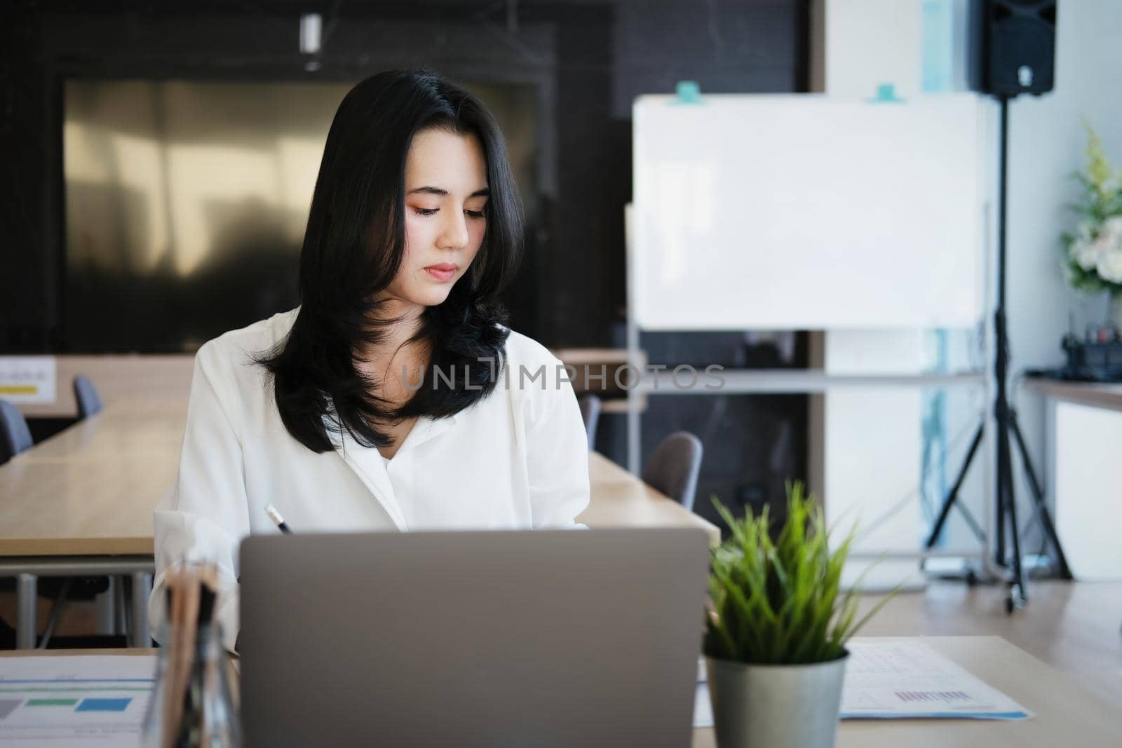 new normal, a businesswoman uses a computer to work for a company Via the internet on your desk at home. by Manastrong