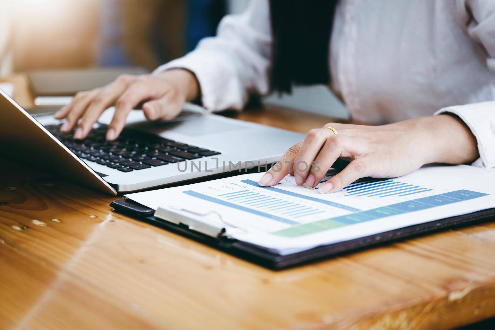 Business woman pointing document to review balance sheet annual and use computer to calculating budget. for audit and Check integrity before investment