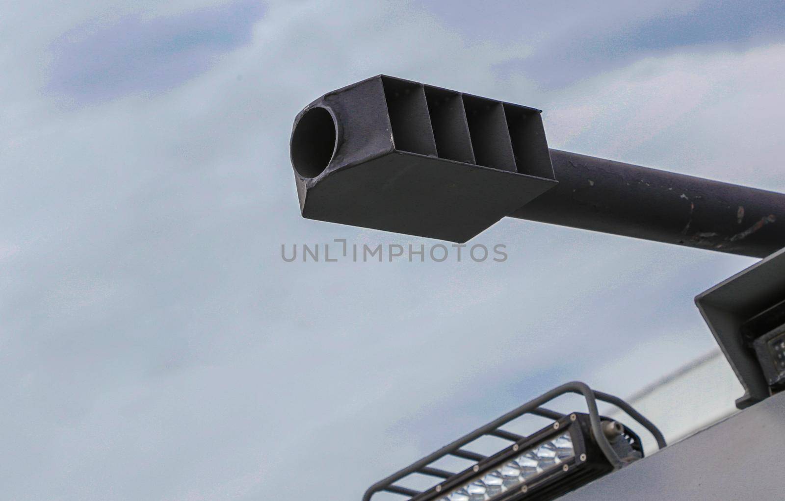 Close-up of the muzzle of a tank gun. A fragment of a cannon and a lantern in front of the tank.