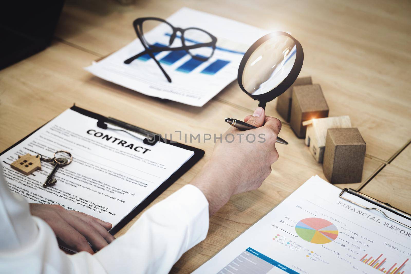 Inspector Concept, a customer is holding a magnifying glass to look at each house model to check the price of a home loan for each model. by Manastrong