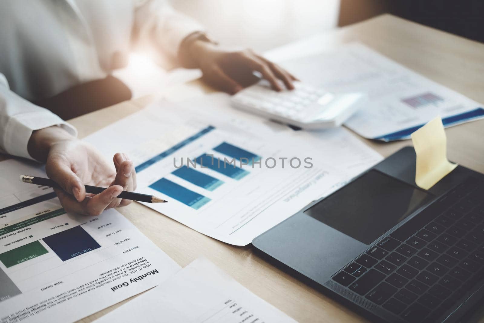 focus woman holding a pencil Auditors use budget document calculators to find annual budget disbursement errors. by Manastrong