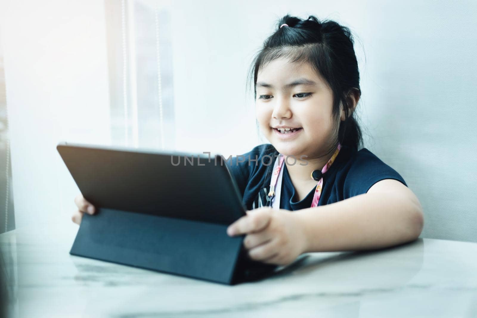 E-learning ,online education and internet social distancing protect from COVID-19 viruses concept. Asian children student video conference e-learning with teacher on tablet computer at home. by Manastrong