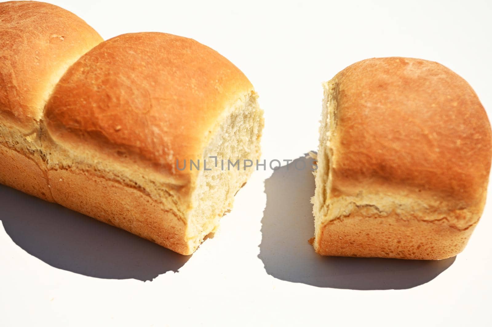 Close-up. Cropped view of loaves of freshly baked whole grain bread isolated on white background with copy ad space by artgf