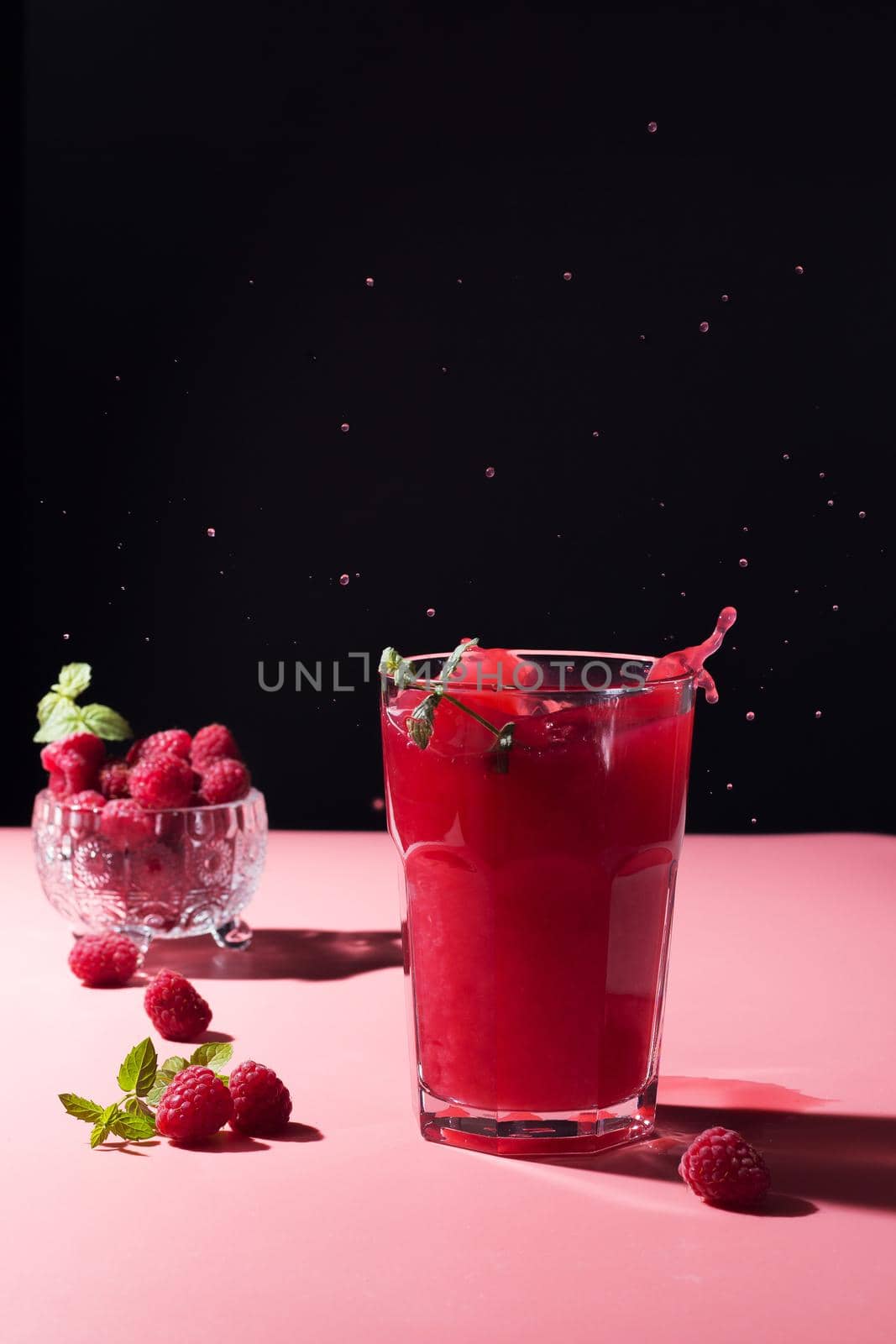 splash of raspberry cocktail on pink background by lara29