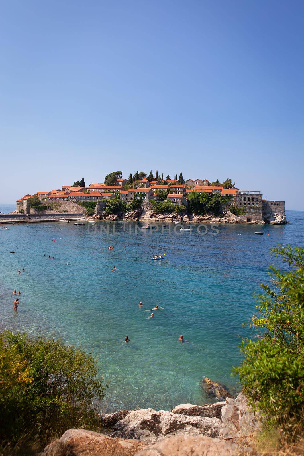 Saint Stephen, Montenegro, 07.07.2021: Famous architectural monument of an island resort in the Adriatic Sea, Montenegro. The concept of recreation at sea, people bathe in the sea