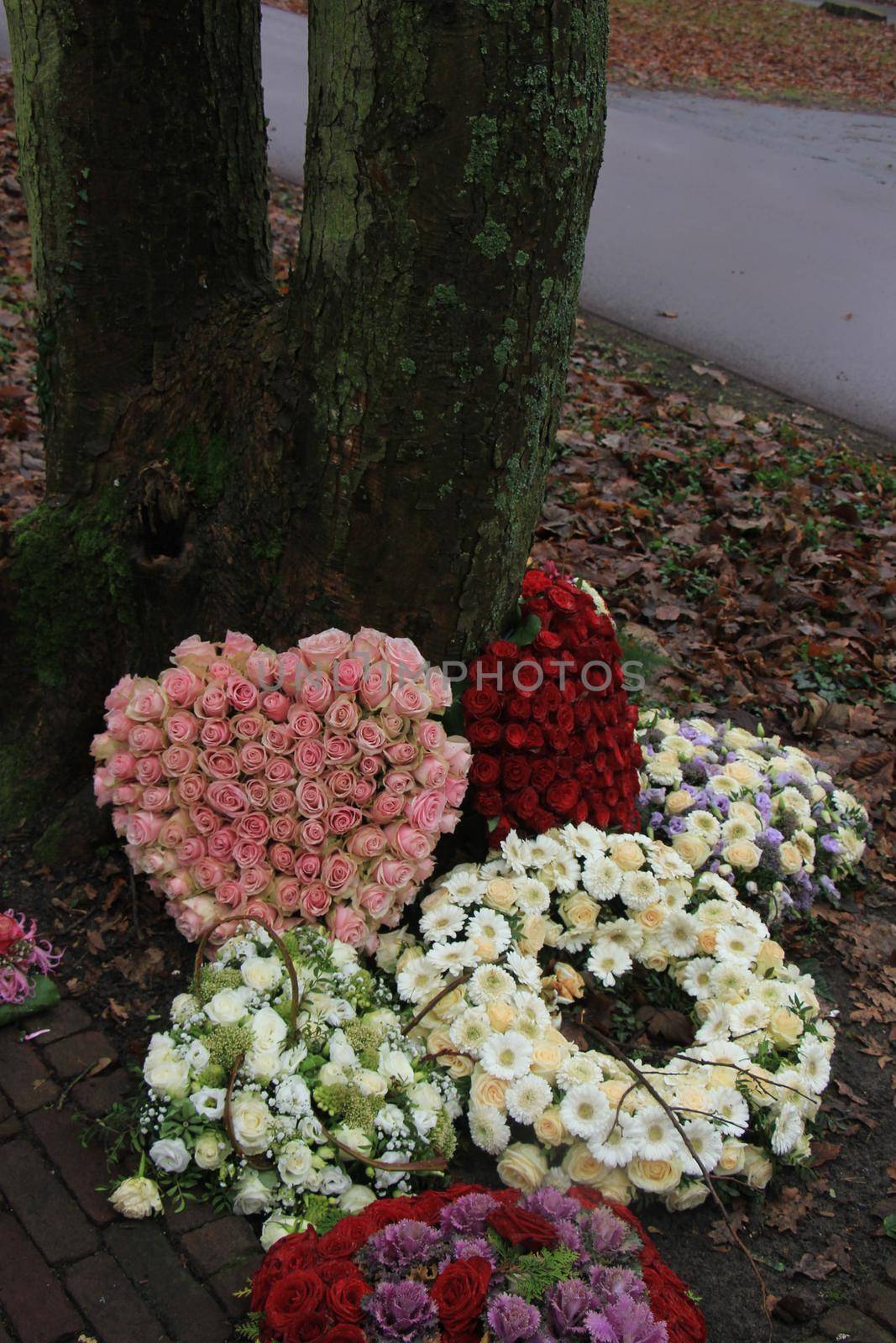 sympathy or funeral flowers near a tree