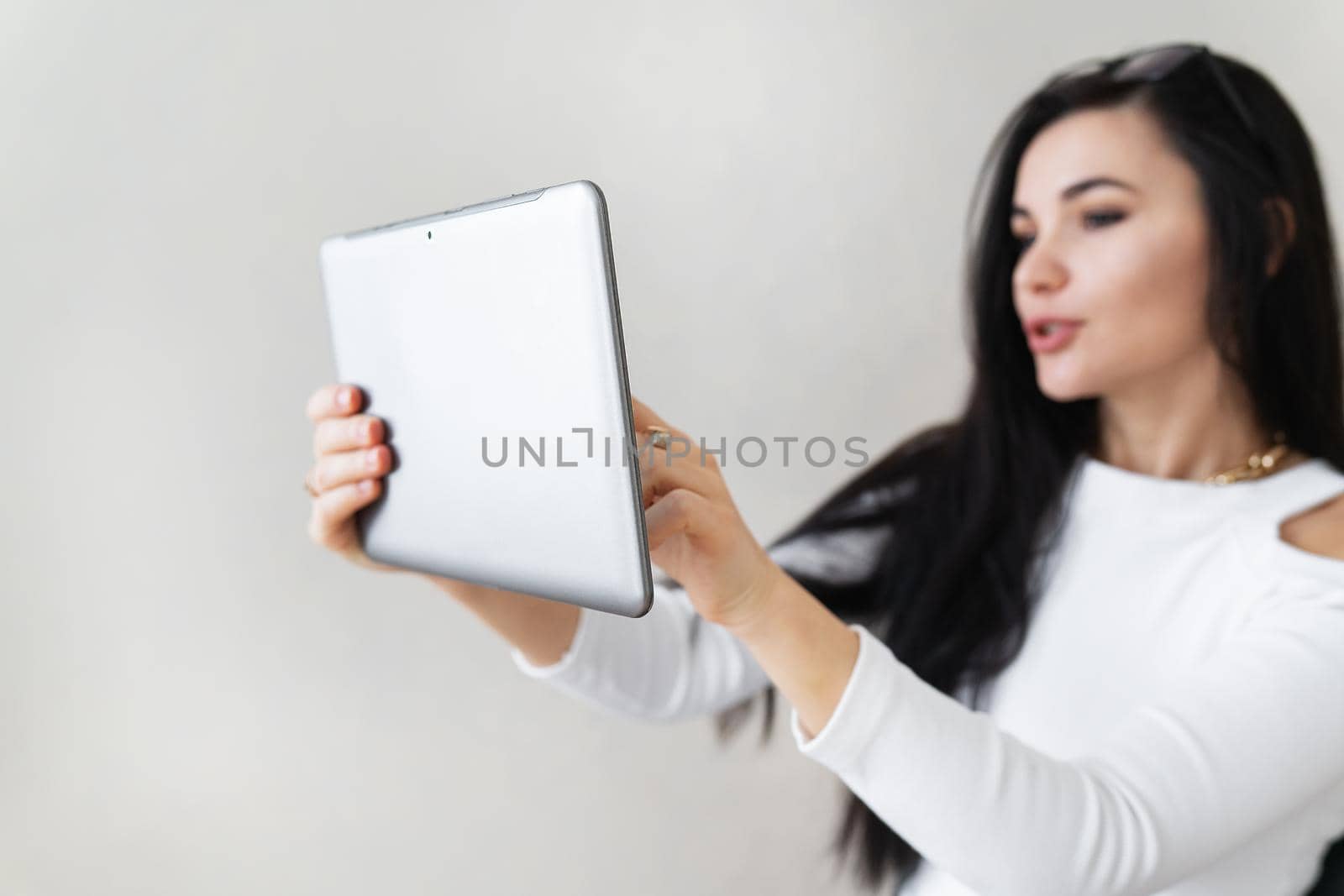 A young business girl speaks on a video call, explains the robot on a video call. Young woman chatting on a virtual online conference. Concept of communication pose by office, online work