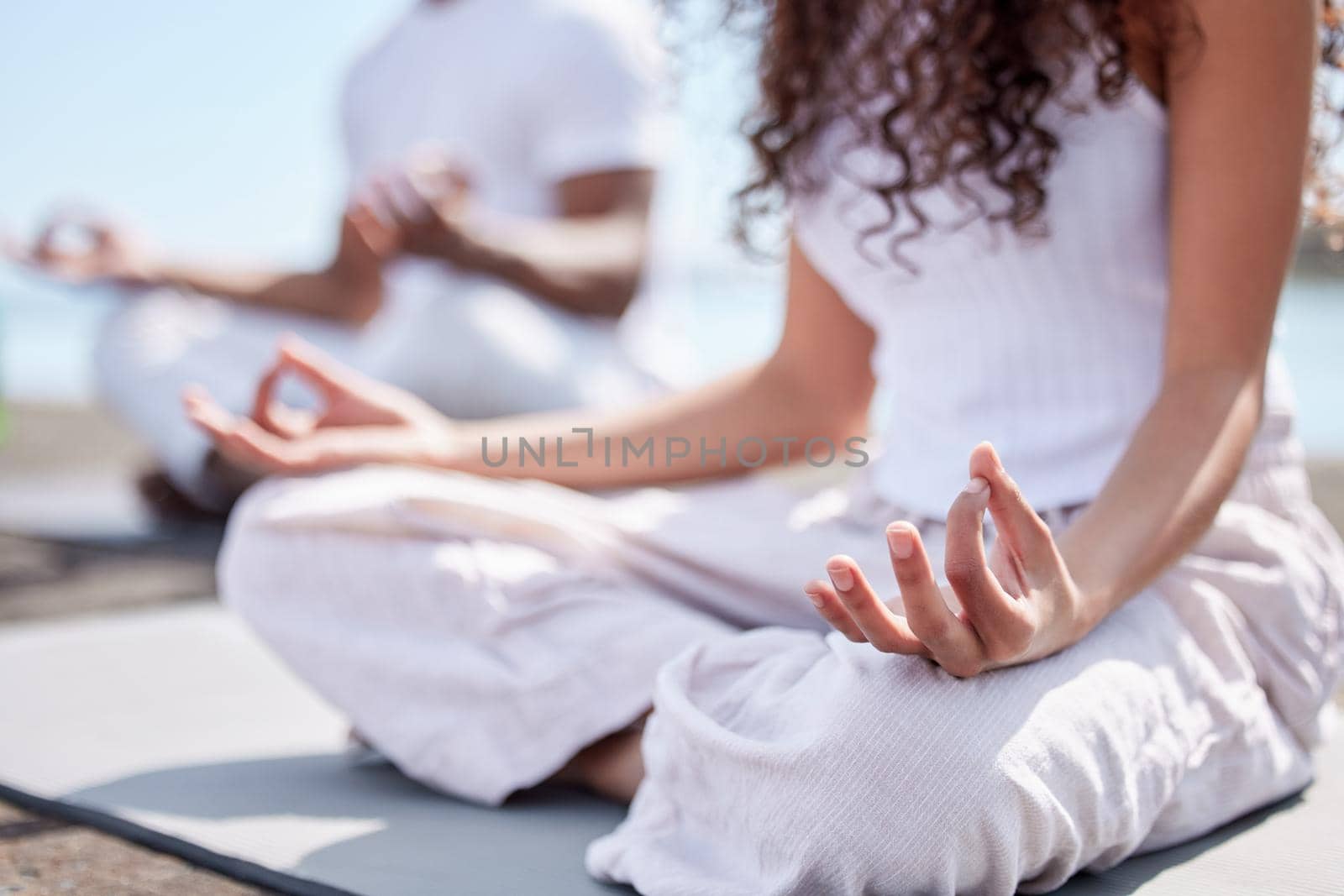 Free your mind. an unrecognizable couple practicing yoga at the beach. by YuriArcurs