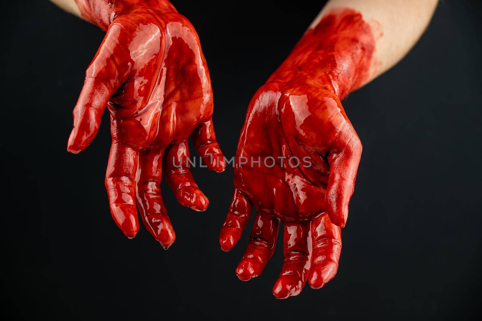 Women's hands in blood on a black background